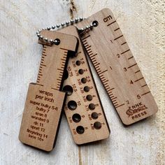 three wooden rulers with words on them are hanging from a chain that is attached to a piece of wood