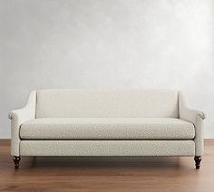 a white couch sitting on top of a hard wood floor