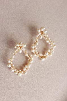 Our Portofino Earring features ivory fresh water pearls that are hand strung along a delicate gold wire to form these pearl wreath drop earrings. They pair perfectly with our Pismo Pearl Hair Pins or Coastal Pearl Hairpins.Details: Natural fresh water pearls cultured from mussels Post: Stainless Steel Dimensions: 2.5 x 1.5 in. Final Sale Pearl Wreath, Pearl Hair Pins, Bridal Earrings Pearl, Fresh Water Pearls, Water Pearls, Pearl Hair, Bridal Pearls, Gold Wire, Bridal Looks