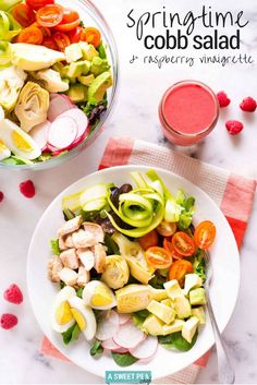 a white plate topped with salad and veggies next to a glass of juice