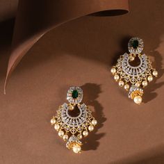 Description Adorned with shimmering CZ stones throughout and embellished with freshwater pearl drops, these timeless chandbali earrings are perfect for every occasion. Their traditional Indian design patterns exude a sense of regal sophistication. Whether paired with an ethnic Anarkali or a traditional silk saree, they add a touch of elegance and grace to any festive ensemble. Details & Specifications: Materials used: CZ Stone with White Gold Plating Weight - Earrings 20.5 gm Length - Earrings 6 White Stone Chandbali Earrings Gold, Luxury Chandbali Bridal Earrings, Luxury Chandbali Earrings With Elegant Design, Affordable Gold Chandbali Danglers, Chandbali Earrings Gold, Traditional Silk Saree, Chandbali Earrings, Indian Wedding Wear, Gold Earrings Designs