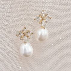 pair of pearl and crystal earrings on white fabric