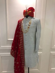 a mannequin wearing a red and white suit with a red scarf on it's head