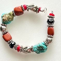 This natural gemstone bracelet has turquoise and carnelian nuggets. It also has faceted black glass beads and glass coral colored heishi beads. It is also accented with ornate silver beads and nuggets. The beaded spacers are in silver tone. 9 inches Thank you for visiting my shop! LOVE, LUCK AND BLESSINGS🌹 Artisan Orange Hand-strung Beaded Bracelets, Glass Coral, Southwestern Style Multicolor Hand-strung Beads, Elegant Turquoise Multi-stone Bracelets, Orange Multi-strand Polished Beads Jewelry, Southwestern Turquoise Multi-stone Bracelets, Heishi Beads, Coral Color, Jewelry Lookbook