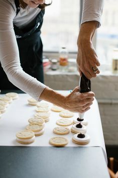 a woman is making cookies on a table