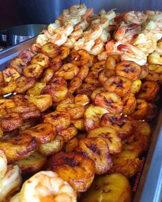 there are many different types of food in the trays on this table, including bananas and shrimp