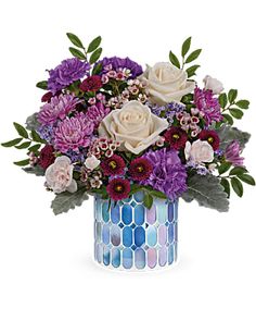 a blue vase filled with purple and white flowers