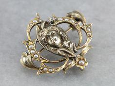 Feminine and flowing, this brooch is a classic example of the romantic Art Nouveau era! The lady is beautiful, with flowers and plant life swirling about her in a natural, ethereal way. This is a classic piece of imagery from the extremely popular artistic movement of the early 1900's, and would make a wonderful everyday piece for an artistic lady! Metal: 14K Yellow Gold Gem: Diamond .03 Carats Gem Measurements: 1.7 mm, Round Accents: Seed Pearls Measurements: 27 x 28 mm Marks: "14K" Stamped on Nouveau Tattoo, Vintage Drop Earrings, Market Square, Pearl Pin, Cameo Ring, Antique Brooches, Romantic Art, Seed Pearl, Yellow Gold Pendants