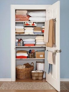 an organized closet with baskets, towels and other items in it's storage area