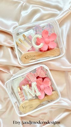 two plastic trays filled with pink and white cake decorating items on top of a bed