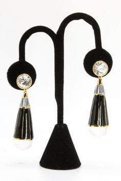 DESCRIPTION: Crafted by renowned designer Rachel Zoe, these earrings are a testament to her signature style and attention to detail. Featuring tear-drop shaped glass with black enameling suspended from round glass crystals set on a gold-tone metal base, they exude sophistication and glamour. Marked with "RACHEL ZOE," these earrings are a symbol of quality craftsmanship. In mint condition and equipped with post backings, they measure 2 1/4" in length and 16mm in diameter, making them a versatile Designer Glass, Crystal Set, Rachel Zoe, Glass Crystal, Tear Drop, Black Enamel, Metal Base, Gold Tone Metal, Signature Style