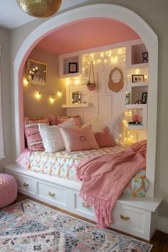 a bedroom with pink walls and lights on the headboard is decorated in pastel colors