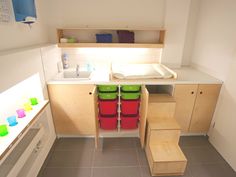 a small kitchen with wooden cabinets and green bins