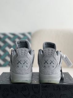 Channel the iconic KAWS x Air Jordan 4 with these inspired sneakers. They feature the same cool grey suede upper, complete with the distinctive "XX" pattern. Meticulous attention to detail ensures a look and feel that rivals the original, at a fraction of the price. Experience the legendary style and comfort of the coveted Kaws Jordan 4. Gray Suede Sneakers With Boost Midsole, Modern Gray High-top Sneakers With Translucent Outsole, Gray High-top Sneakers With Perforations For Streetwear, Fall Winter Jacket, Air Jordan 4 Retro, Loafer Sneakers, Bottega Veneta Shoulder Bag, Gray Suede, Air Jordan