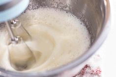 a mixer filled with white liquid on top of a table