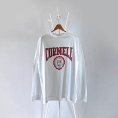 90s Cornell University athletic long-sleeves t-shirt/ XL * PLEASE READ BEFORE PURCHASE * PLEASE consider the PHOTOS before making the decision * The images may DIFFER in appearance from the actual product because we took pictures under daylight.  * PLEASE send your PHONE NUMBER after your purchase for the shipping company to contact you X No returns X No refund Condition : 9/10 More details : look at the pictures  Brand : Anvil Size On Tag : XL Pit to pit/ Chests : 23,5/47 inches  Length : 30 inches  Material : cotton polyester  Color : white  * Payment accept PayPal only * ALL ITEMS are VINTAGE which may show some signs of wear and tear * Due to the different display and different light, the picture may not reflect the actual color of the item Thank you RG/27/8/23 Long Sleeve Sweatshirt With Logo Print For Campus, Long Sleeve Logo Print Sweatshirt For Campus, Varsity Long Sleeve Tops For Campus, 90s Long Sleeve Tops For Streetwear, Cotton Long Sleeve T-shirt For Campus, Relaxed Fit Long Sleeve Tops For Campus, Sporty Long Sleeve T-shirt For Campus, Sporty Long Sleeve Tops For Campus, Vintage Long Sleeve Tops For Campus