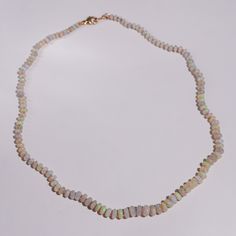 Discover the enchanting beauty of our Australian Opal Knotted Candy Bead Necklace, a stunning piece that captures the mesmerizing play of colors. This 18-inch necklace features smooth opal beads that shimmer with hues of teal, purple, green, and yellow, creating a vibrant and dynamic look. Each bead is meticulously knotted with luxurious lavender silk, enhancing the necklace’s elegance and durability. The opals rest on a cream-white base, providing a perfect backdrop that highlights their natura Opal Beaded Necklaces For Jewelry Making, Opal Beaded Necklace Gift, Beaded Opal Necklace For Gift, Opal Beaded Necklace For Gift, White Beaded Opal Jewelry, Gemstone Necklace With Ethiopian Opal Round Beads, Single Strand Opal Necklace As Gift, Elegant Single Strand Ethiopian Opal Jewelry, Elegant Ethiopian Opal Gemstone Beads Jewelry