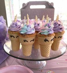 there are cupcakes with purple frosting and unicorn decorations on top of them