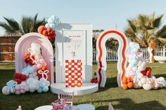 an outdoor party with balloons and decorations