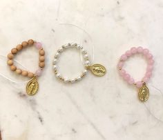 🔹This is a girl's catholic rosary bracelet. You will never have to be without your rosary when you can wear it around your wrist. 🔹Available in 4 different styles; wood with rose quartz beads, white glass pearl beads, pink glass pearl beads or rose quartz beads. Each bracelet includes a 1 inch gold plated miraculous medal pendant. Unless otherwise specified the bracelet will be made to 5.5 inches (3-7 year old). 🔹Each set is packed in a beautiful organza bag and a handwritten gift message can also be included. It makes the perfect gift for Christmas, baptism, first communion or gift for a flower girl. 🔹Care tips - Treat and store bracelets gently - Please roll bracelets on and off gently. Repeated stretching can weaken the elastic and shorten the life of your bracelets.  - Avoid excess Spiritual Round Beads Bracelets For Baptism, Adjustable Rosary Bracelet For First Communion And Mother's Day, Handmade Adjustable Rosary Bracelet For First Communion, Adjustable 8mm Beads Rosary Bracelet For Baptism, Adjustable Rosary Bracelet With Miraculous Medal For First Communion, Adjustable Pink Rosary Bracelet For First Communion, Catholic Rosary Bracelet, Catholic Rosary, Gift Flower