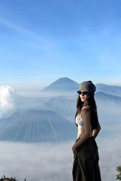 a woman standing on top of a mountain