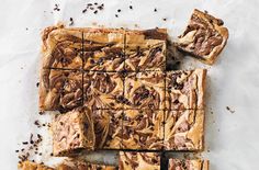 chocolate swirled brownies cut into squares on top of parchment paper