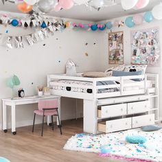 a bedroom with white furniture and balloons hanging from the ceiling