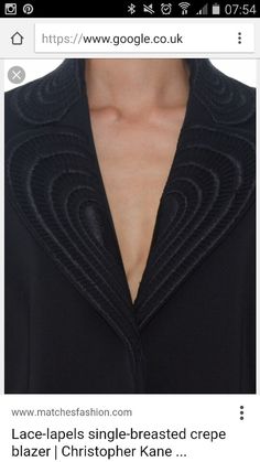 a close up of a person's chest wearing a black shirt with an open collar