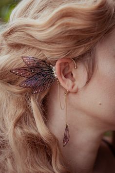 A golden fairy earcuff handmade with love and pixie dust. Some fairy wings are atteached to the earcuff that you can clip easy behind your ear, no ear piercing needed. The wings and the earcuff are emebellished with some rhinestones. A small chain hangs at the earcuff and ends with another fairy wing. In your order is just one earcuff. The earcuff fits everyone. Measurements (wings): Length: ~6,5cm Width: ~7,5cm Chain with the wing: ~8cm Materials: metal, rhinestones Every piece is made by me wi Golden Cuffs, Cherry Blossom Fairy, Golden Fairy, Leaf Ear Cuffs, Fairy Ears, Ear Cuff Jewelry, Fairy Accessories, Ear Accessories, Fairy Jewelry