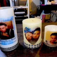 three personalized candles sitting on top of a table next to each other with pictures