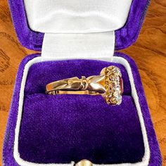 a gold ring in a purple velvet case