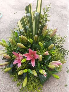 a bunch of flowers that are sitting on the ground next to some grass and plants