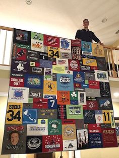 a man standing on top of a giant quilt made out of t - shirt shirts