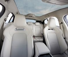 the interior of a car with all white leather seats and dashboards, looking up at the sky