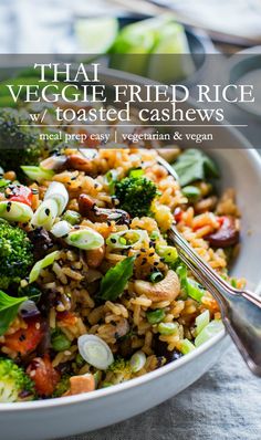 thai fried rice with vegetables and cashews in a white bowl on a table