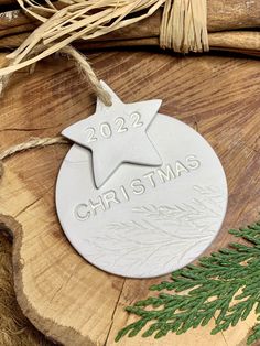 a christmas ornament on top of a piece of wood next to some branches