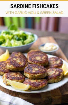 crab cakes with garlic aioli and green salad on a white plate next to a bowl of broccoli