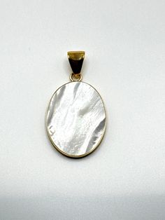 Charles Albert Designer Mother of Pearl White Oval Pendant is Bezel set in their Signature Alchemia Gold.  A Lovely White color in this Cultured Mother of Pearl Cabochon pendant .  Pendant is open on the back revealing a lovely mother of pearl coloring.  This lovely Pendant is a Charles Albert White Mother of Pearl Oval Pendant set in Alchemia Gold  and signed by the designer 'Charles Albert' inside of the bail.  Pendant hangs 2.25 inches from the top of the bail.  Pendant itself is 1.6 x 1.25 Inch Oval Shape.  Really pretty pendant for any Pearl lover!  Pearl is the June Birthstone!  Charles Albert Gold Tone Paperclip Chain not included in price of the pendant, but available in variations in 18, 24, 30 and 36 inch lengths. A Charles Albert Designer Mother of Pearl White Pendant set in the White Oval Pendant With Polished Finish, Oval Mother Of Pearl Gemstone Jewelry, Oval Mother Of Pearl Jewelry With Polished Finish, White Oval Pearl Pendant Jewelry, Oval Pearl Pendant Jewelry, White Oval Cabochon Jewelry, White Cabochon Mother Of Pearl Jewelry, White Mother Of Pearl Cabochon Jewelry, White Cabochon Oval Pendant Jewelry