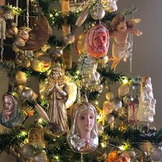 a christmas tree with ornaments hanging from it's sides and angels on the top