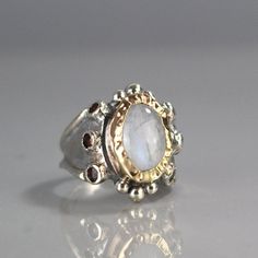 "Moonstone Ring, Garnet Ring, 9K Yellow Gold Hammered Queen Ring in Sterling Silver Band, Gemstone Ring, Antique Style Ring, Chunky Ring This garnet and moonstone ring looks like it was made for a queen. It is ornate but delicate, statement piece but not oversize. The band is adjustbale to any finger size and made of sterling silver set with dark red natural garnet gemstone. The center is a bezel set moonstone gemstone and 9K solid gold, welded on sterling silver, hammered around the moonstone. Queen Rings, Antique Style Rings, Pink Engagement Ring, Chunky Ring, Razzle Dazzle, Chunky Rings, Ring Antique, Garnet Ring, Garnet Rings