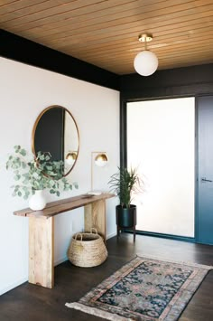 a room with a rug, mirror and potted plant