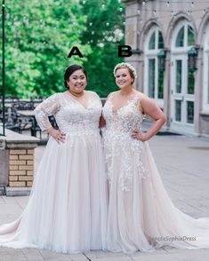 two women standing next to each other in front of a building