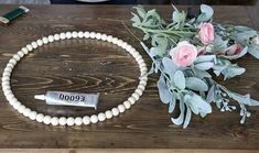 a white beaded necklace with flowers and a tube of eco toothpaste next to it