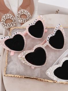 three pairs of heart shaped sunglasses sitting on top of a table