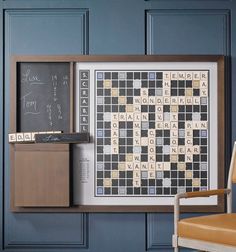 a framed scrabble board on the wall next to a chair and a chalkboard