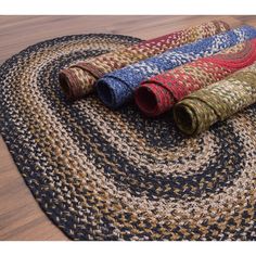 three braided rugs on the floor with one rolled up and another rolled down