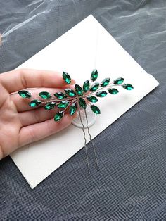 Emerald hair pin is the perfect wedding hair accessory for the bride.  The hair piece is flexible and lightweight.  The width of the hair piece is 4 inches. Bridal hair accessory is available in any color of rhinestones and wire. * All orders from the Exclusive Wedding Shop you will receive in a FREE beautiful gift box. * Standard shipping: - USA: 12-15 business days - Europe: 3-5 weeks - Canada: 6-10 weeks - Australia: 6-10 weeks - Rest of World: 4-10 weeks * Express shipping UPS: 7-9 business Emerald Hair Accessories, Crystal Hair Pins Wedding, Wedding Hair Pins Crystal, Emerald Hair, Wedding Hair Pin, Hair Pins Wedding, Bridesmaid Hair Pins, Gift For Bridesmaids, Rhinestone Hair Pin