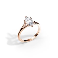 a rose gold ring with a pear shaped diamond in the center, on a white background