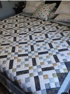 a bed with two pillows on top of it and a quilted bedspread