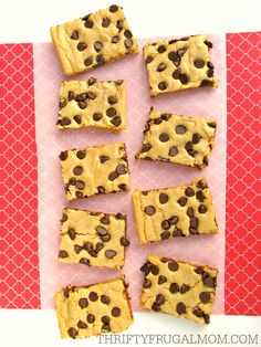 chocolate chip cookie bars cut into squares on a pink and red background